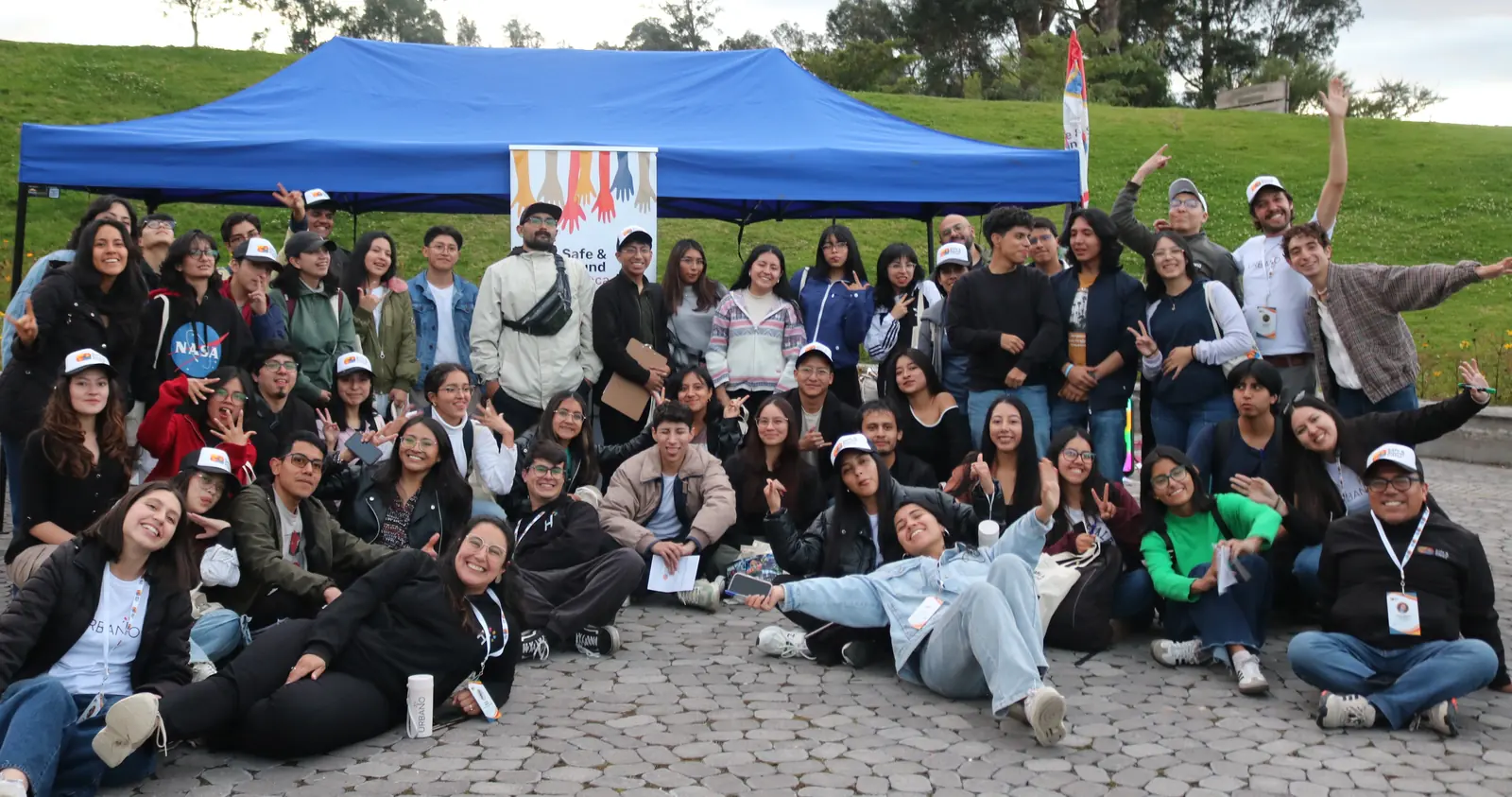 Jóvenes de la Escuela URBANO y el equipo de S2Cities Ecuador reunidos frente a una carpa en un encuentro al aire libre