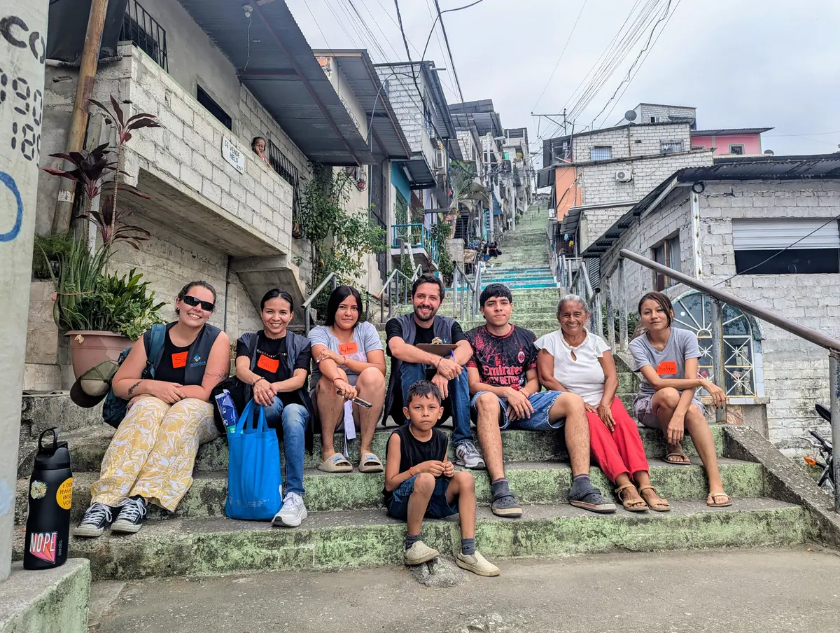Jóvenes y vecinos de Mapasingue Este junto al equipo de Integrar, sentados en la escalinata del barrio